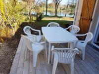 a white table and chairs sitting on a porch at Maison d&#39;une chambre avec vue sur le lac piscine partagee et jardin amenage a Hourtin in Hourtin