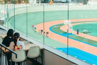a group of people sitting in a volleyball court at SETOUCHI KEIRIN HOTEL 10 by Onko Chishin in Tamano
