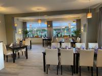 ein Esszimmer mit Tischen und weißen Stühlen in der Unterkunft Landgasthof Struckum in Struckum