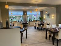ein Speisesaal mit Tischen und Stühlen in einem Restaurant in der Unterkunft Landgasthof Struckum in Struckum