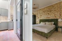 ein Schlafzimmer mit einem Bett und einer Steinmauer in der Unterkunft Splendid Parisian Flat 5P - Montorgueil in Paris