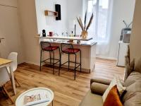 ein Wohnzimmer mit einer Küche mit einer Theke und 2 Barhockern in der Unterkunft Meublés du chêne vert, cœur de Jarnac in Jarnac