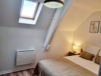 Schlafzimmer mit einem Bett und einem Fenster in der Unterkunft Meublés du chêne vert, cœur de Jarnac in Jarnac