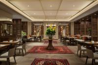 a restaurant with tables and chairs and a vase of flowers at Grand Hyatt Jakarta in Jakarta