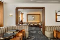 een wachtkamer met tafels en stoelen en een spiegel bij Pavillon Faubourg Saint-Germain & Spa in Parijs