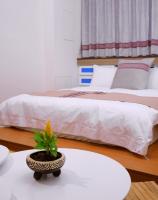 a hotel room with two beds and a plant on a table at Mixa Hostel in Hualien City