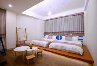 a bedroom with two beds and a table and a table at Mixa Hostel in Hualien City