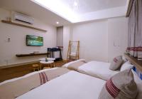 a hotel room with three beds and a table at Mixa Hostel in Hualien City