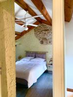 a bedroom with a bed in a stone wall at Bedousses in Aujac