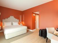 a bedroom with a white bed and an orange wall at Lutecia Smart Design Hotel in Lisbon