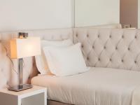 a white bed with a white pillow and a lamp at Lutecia Smart Design Hotel in Lisbon