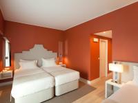 a bedroom with two beds and orange walls at Lutecia Smart Design Hotel in Lisbon