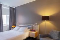a bedroom with a bed and a chair and a lamp at NU Hotel in Brooklyn
