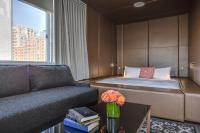 a bedroom with a bed and a couch and a table at NU Hotel in Brooklyn