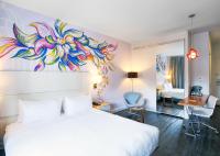a bedroom with a bed with a painting on the wall at NU Hotel in Brooklyn