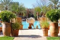 a woman in a swimming pool with a fountain at Domaine Des Remparts Hotel &amp; Spa in Marrakech