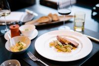 ein Tisch mit einem Teller Essen und Gläsern Wein in der Unterkunft Schlosshotel Hugenpoet in Essen