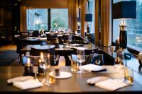 ein Restaurant mit Tischen, weißen Servietten und Stühlen in der Unterkunft Schlosshotel Hugenpoet in Essen