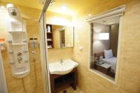 a bathroom with a sink and a mirror and a bed at Kindness Hotel - Tainan Chihkan Tower in Tainan