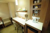 a hospital room with a desk and a mirror at Kindness Hotel - Tainan Chihkan Tower in Tainan