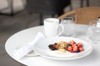 een bord met eten op tafel met een kopje melk bij Hotel Mortagne in Boucherville