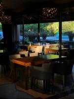 Un restaurante con mesas y sillas y un gran ventanal. en Mestizo Hotel, en Lincoln