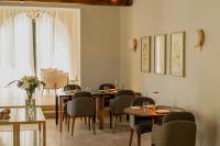 Un comedor con mesas y sillas y una ventana. en Susana Balbo Winemaker's House - Relais & Chateaux, en Ciudad Lujan de Cuyo