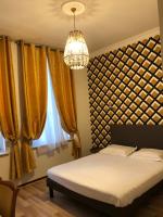 a bedroom with a bed and a chandelier at Hôtel Emilie in Royan