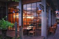 Swarga Suites Bali Berawa, Marclan Collection في تشانغو: مطعم مع طاولة وكراسي في نافذة