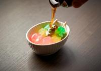 京都市にあるホテル空京都のキャンディーの入ったボウルにソースを注いでいる人