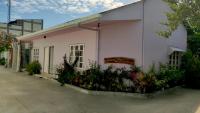 Un edificio blanco con flores delante. en Moodhumaa Inn, en Guraidhoo