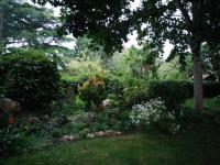 a garden with flowers and plants in a yard at Les Clés du Parc in Combrand