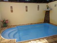 a swimming pool in a backyard with a house at Casa com Piscina Paraty in Paraty