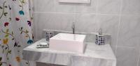 a bathroom with a white sink and a shower curtain at Casa com Piscina Paraty in Paraty
