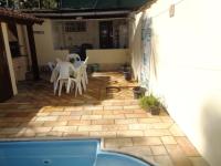 a patio with a table and chairs and a pool at Casa com Piscina Paraty in Paraty