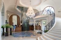 a lobby with a staircase and a chandelier at Hôtel Royal in Évian-les-Bains