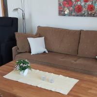 a brown couch with a table with flowers on it at Vila Vivvi in Ražanac