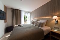 a hotel room with a large bed with a window at Golden Tulip Sophia Antipolis - Hotel &amp; Spa in Valbonne
