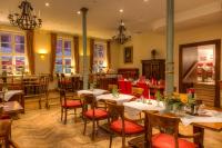 a restaurant with tables and chairs in a room at Hotel Zum Bär in Quedlinburg