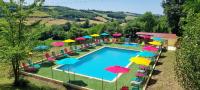 - une vue sur la piscine et ses parasols colorés dans l&#39;établissement Camping Le Bourdieu, à Durfort