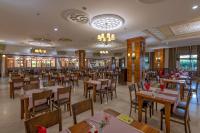 a dining room with wooden tables and chairs at Lake River Side Hotel Spa in Side