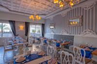 a dining room with tables and chairs and a chandelier at Lake River Side Hotel Spa in Side