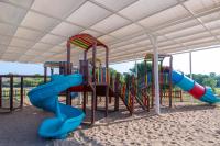 a playground with a slide in the sand at Lake River Side Hotel Spa in Side