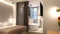 a hotel room with a bed and a bathroom with a sink at MiHotel Sala in Lyon