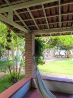 a hammock on a porch with a view of a park at Pousada São Francisco in Cumuruxatiba