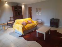 a living room with a yellow bed and a table at La Grange in Le Plan