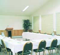 a conference room with white tables and chairs and a podium at Kandahar Lodge at Whitefish Mountain Resort in Whitefish