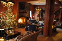 a living room with a christmas tree and a fireplace at Kandahar Lodge at Whitefish Mountain Resort in Whitefish
