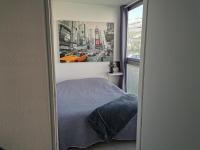 a bedroom with a bed and a picture of a city at Grand studio de 33m² à 300m des plages in Vallauris
