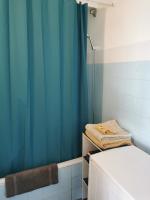 a bathroom with a blue shower curtain and a bed at Grand studio de 33m² à 300m des plages in Vallauris